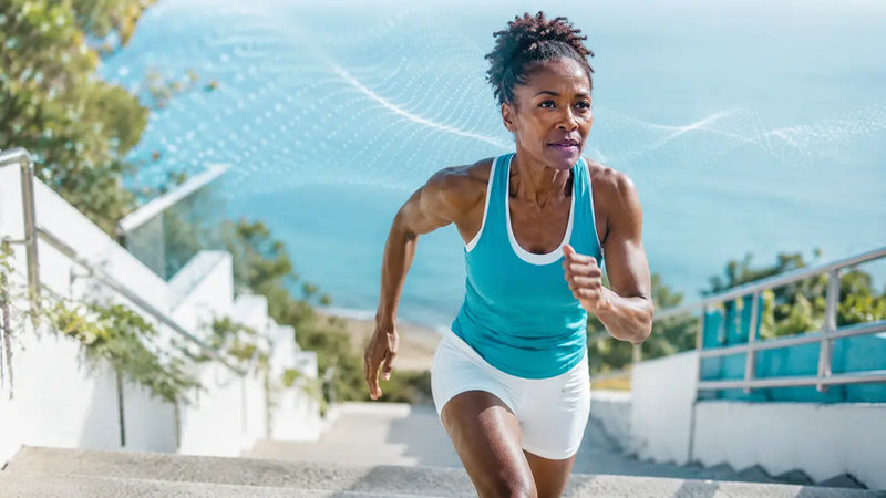 Woman running up outdoor steps, showing clean sugar-free energy as an alternative to energy drinks